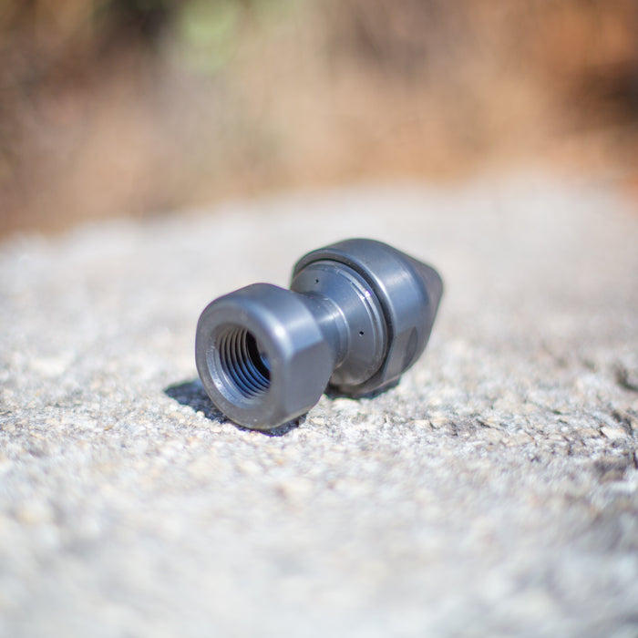 US Jetting threaded sewer jetting nozzle adapter shown on a concrete surface, precision‑machined with internal threads for connecting Egghead Penetrator nozzles and other high‑pressure jetting tools; durable case‑hardened steel fitting used with 1/2", 3/4", and 1" high‑pressure hoses for 2,000–10,000 PSI sewer and drain cleaning applications.