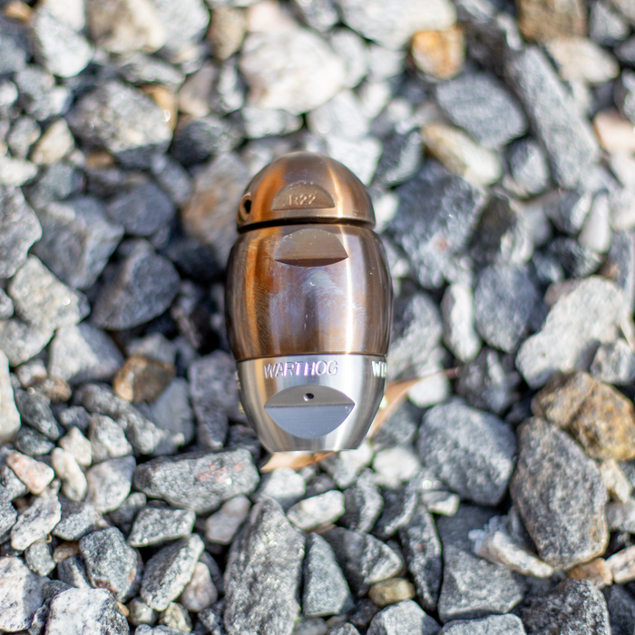 Warthog sewer jetter nozzle resting on gravel, featuring a compact stainless steel body with precision rear and side jet ports engineered for high‑pressure pulling, descaling, and cleaning 3–8 inch sewer and drain lines. Durable, fully rebuildable design with premium components for professional pipeline maintenance and heavy‑duty drain cleaning.