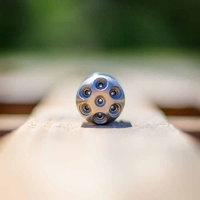 Stainless steel Digger Nozzle for sewer jetting, forward‑jet design with no rear jets to push debris and scale out of small pipes; manually pushed nozzle ideal for short runs under 100 feet during pipe‑lining prep, shown on a wooden surface for detailed product display.