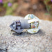 Close‑up of an ENZ Turbo Chain Scraper nozzle on a concrete surface, featuring a heavy‑duty toothed cutting head, rotating chain arm, adjustable chain links, and white centralizing skids. Industrial sewer jetting tool engineered for removing concrete, roots, and grease from 3–8 inch pipes, built for rugged conditions and compatible with jetting machines requiring at least 8 GPM.